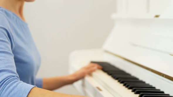 Woman playing piano at home 4k alt