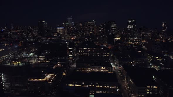 Aerial Floating Over Dark City At Night With Rows Of Skyscraper Buildings alt