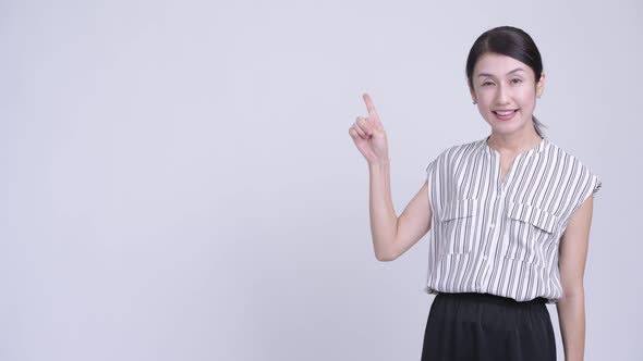 Happy Beautiful Asian Businesswoman Thinking and Pointing Up alt