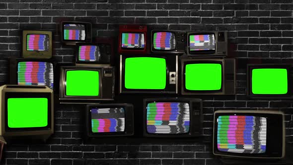 Five Old TVs Green Screen Against Brick Wall.