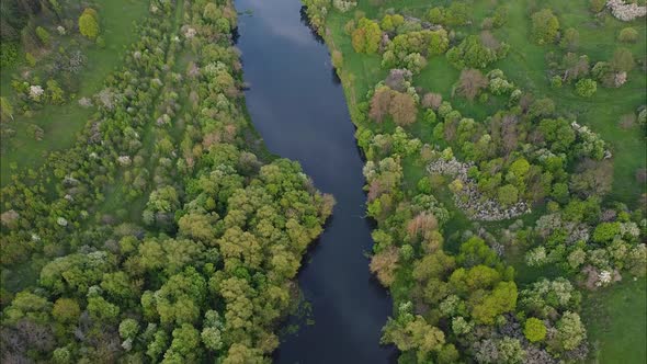 View of the river from above. Flight over water and forest trees from a height alt