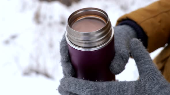 Unrecognizable Person Holding Small Thermos with Hot Chocolate alt