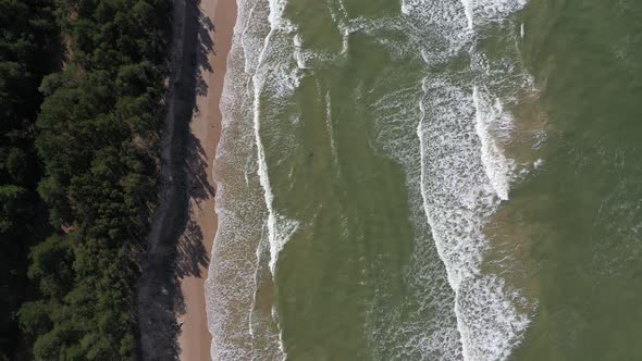 Drone footage of waves crashing against Baltic sea beach 