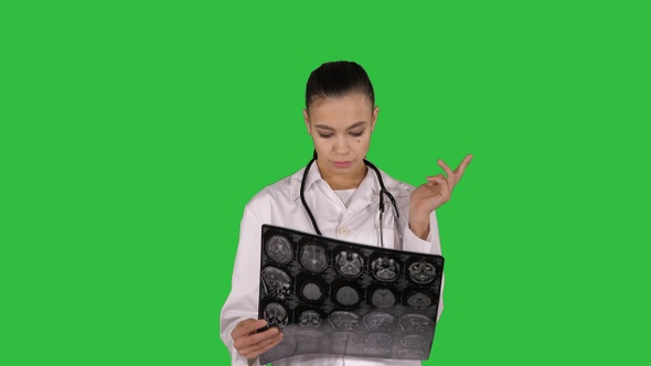 Doctor female with white labcoat looking at x-ray radiographic alt
