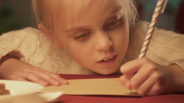 Cute Girl Writing Letter to Santa Claus or Postcard to Wish Merry Christmas alt
