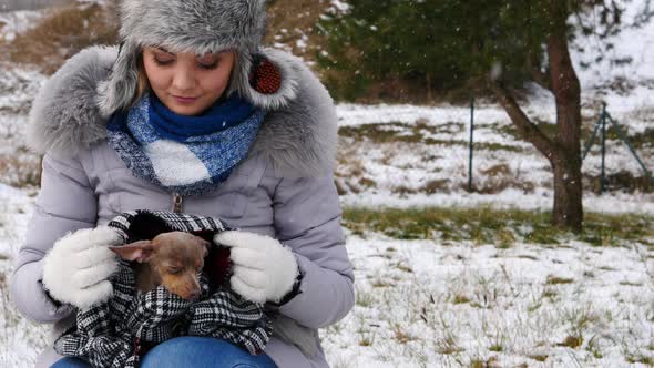 Girl Taking Care of Small Dog during Winter