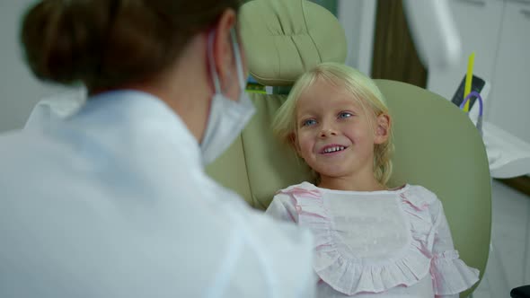 Girl Stopes Smiling While Talking To the Dentist. alt