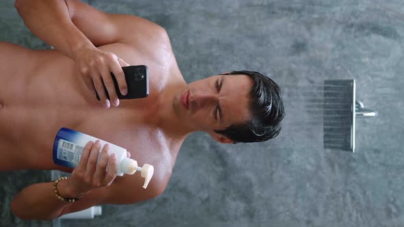 Vertical Video of a Man Looking for Information on the Internet About Body Care Using a Smartphone alt