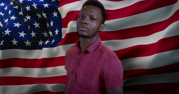 Black Man Smiling for Camera Against American Flag alt