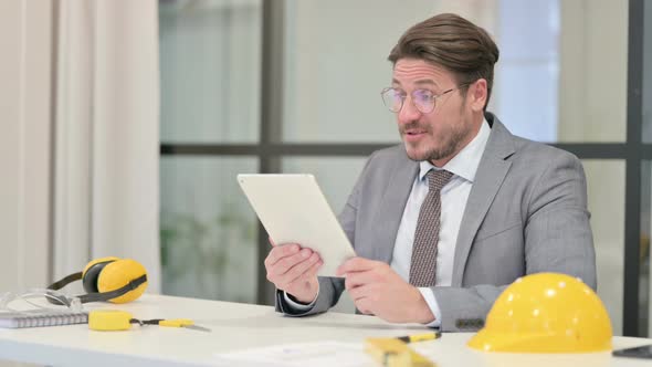 Middle Aged Engineer Reacting to Loss on Tablet in Office alt