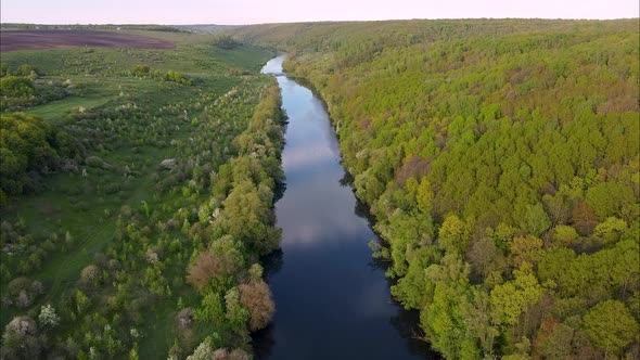 View of the river from above. Flight over water and forest trees from a height alt