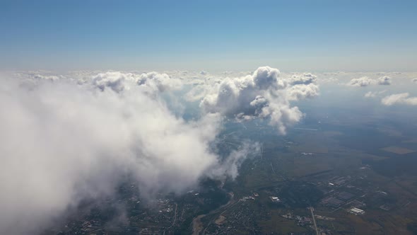 Aerial View From Airplane Window at High Altitude of Earth Covered with White Puffy Cumulus Clouds alt