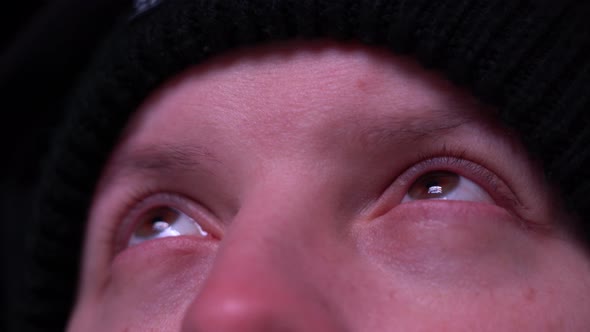 Eyes of a Man Blinking Upward on an Outdoor LED Screen alt