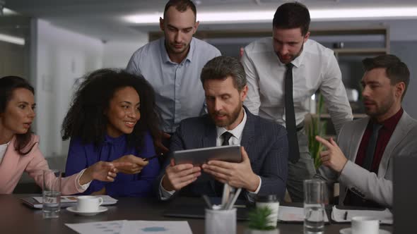 Diverse Executive Team Analyzing Data Using Tablet Device on Office Meeting alt