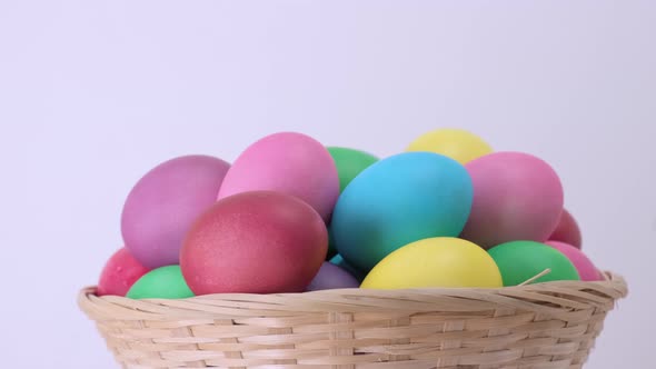 Easter Colorful Chicken Eggs Rotating in Basket on White Background alt