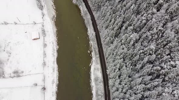 Road beside river and forest in the winter season in Bucovina