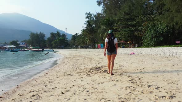 Women tan on tranquil coastline beach holiday by turquoise sea with white sand background of Thailan alt