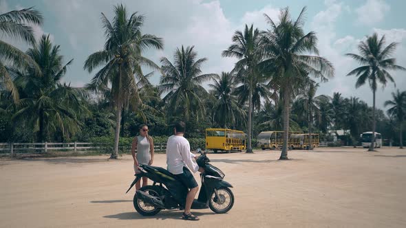 Pretty Woman Stands Near Guy Sitting on Wonderful Motorbike alt