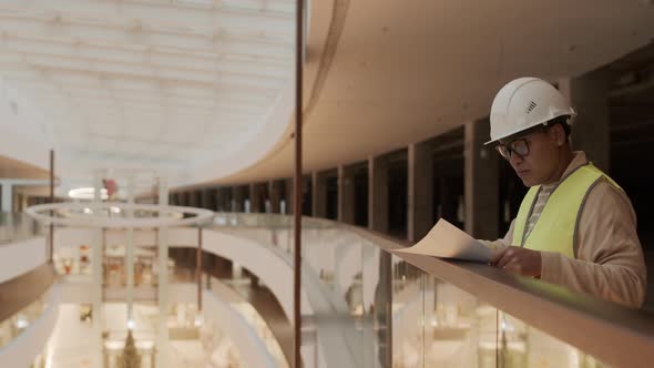 Construction Worker Checking Papers in Mall alt