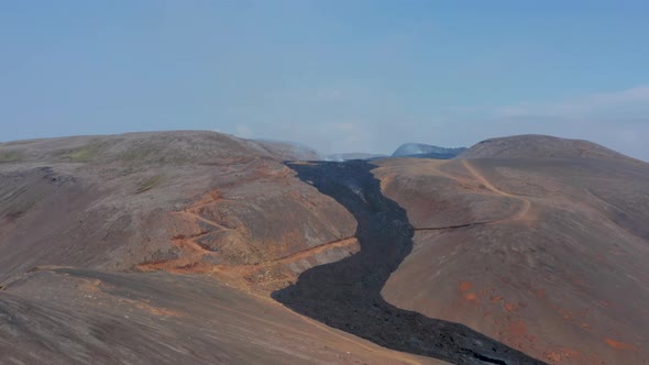 Aerial Circling Around Black Lava River Flowing Between Mountains in Fagradalsfjall Iceland Day alt