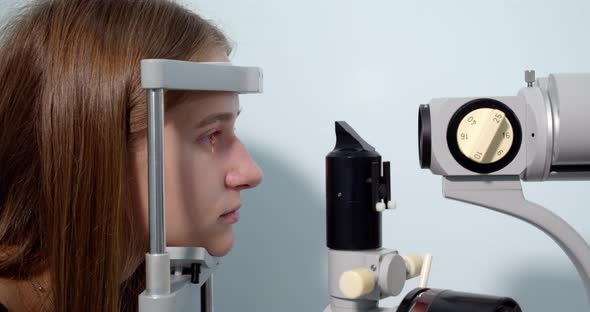 Young Woman Having Her Eyes Examined With Modern Medical Equipment alt