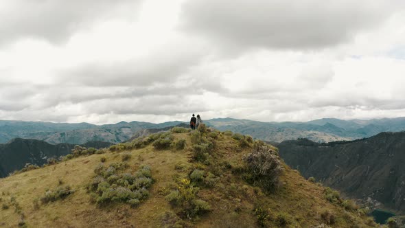 People On The Summit Of Quilotoa Loop Revealing Volcano Lake In Ecuador. Aerial Tilt-up alt