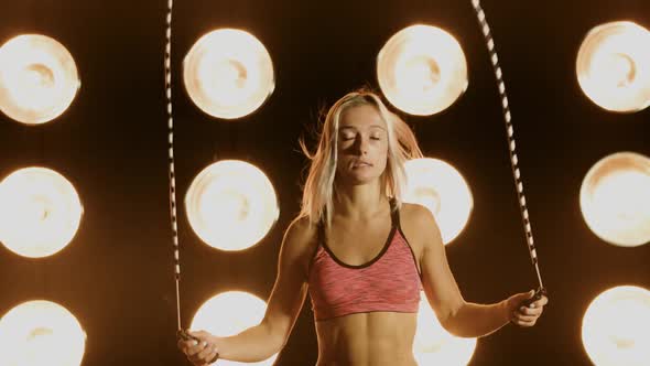Beautiful Woman Working Out In Front Of A Wall Of Lights alt