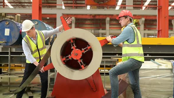 Two young engineers Testing and verifying the operation of the machines alt