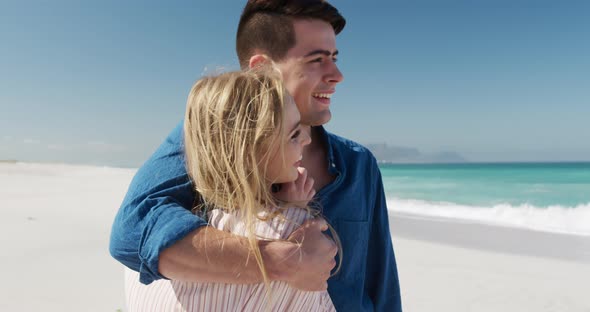 Couple in love enjoying free time on the beach together alt