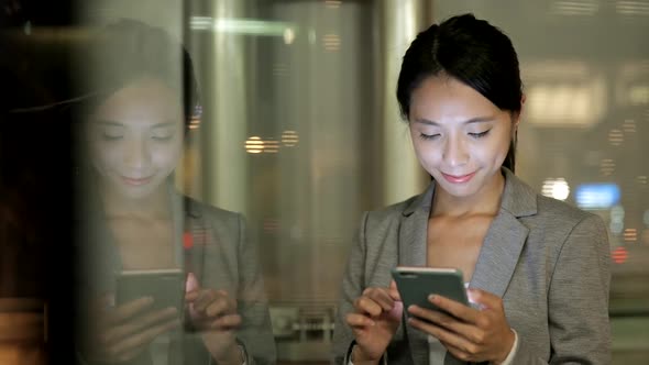 Window reflection of business woman use of smart phone  alt