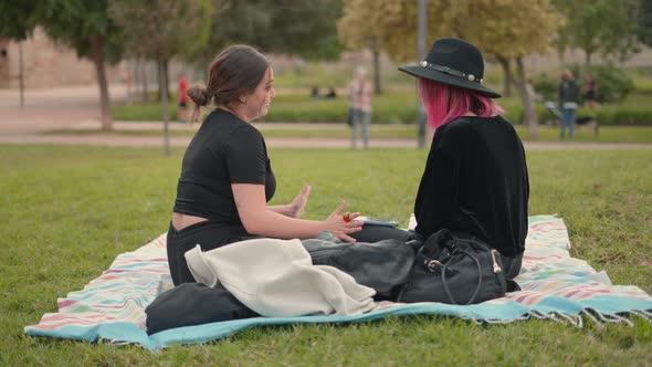 Side View of Two Girls on Black Clothing Interacting at the Park Area alt