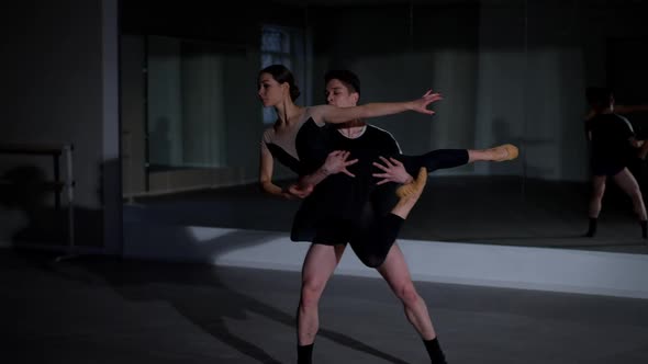 Wide Shot Concentrated Ballet Dancer Performing Pirouette Standing Looking at Camera alt