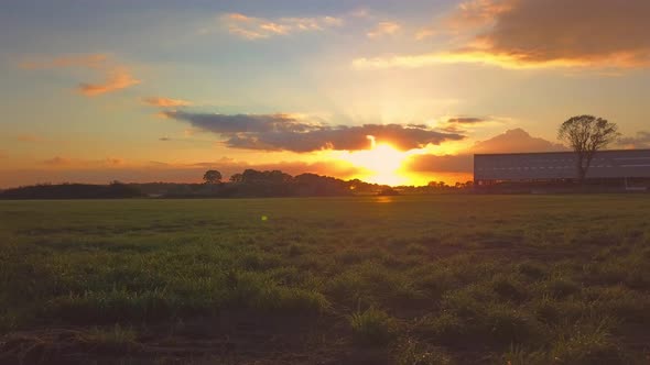 Aerial Cinematic Clip Drone Flying Over a Farm Field During Sunset alt
