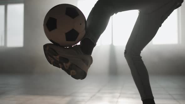 A Closeup Black Man Juggles a Soccer Ball in the Sunlight in the Garage alt