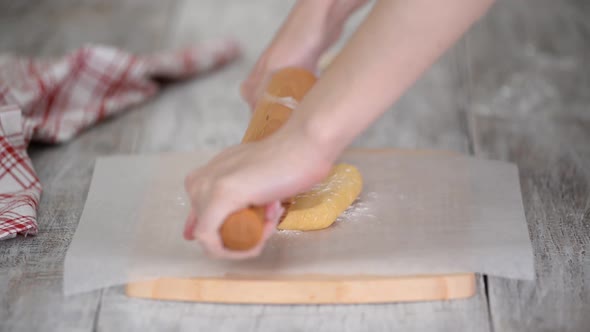 Close Up of Woman Rolling Dough with Rolling Pin on Kitchen