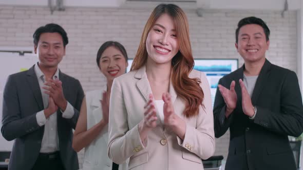 A group of colleagues are clapping their hands in congratulations. alt