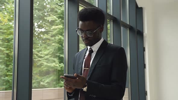 African american man uses business app on smart phone alt