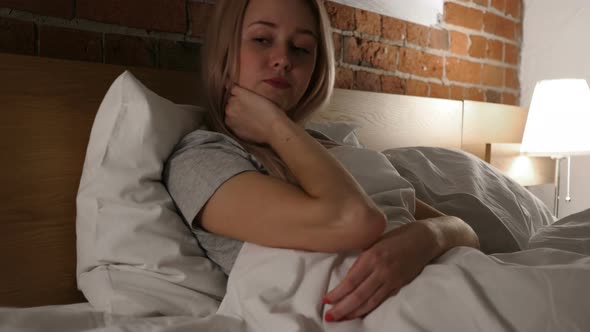 Tired Woman with Pain in Neck, Relaxing in Bed alt