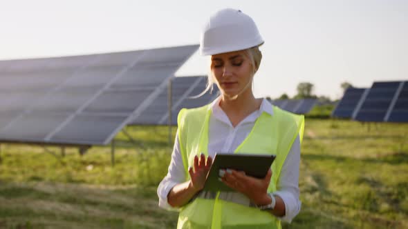 Inspector Engineer Woman Holding Digital Tablet Working in Solar Panels Power Farm Photovoltaic Cell