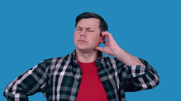 A man is scratching his head thinking about something, blue background.