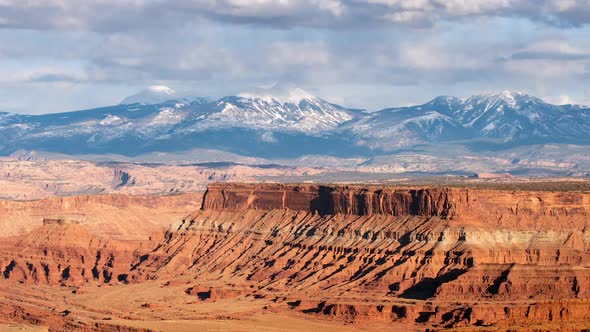 Time lapse of desert mesa and snow covered mountains alt