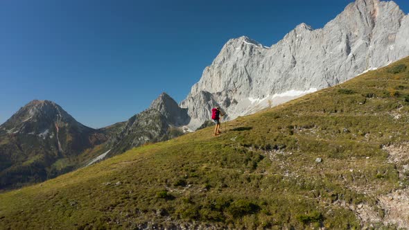 4K Aerial View Sporty Woman Hiking High up in Alpine Mountains