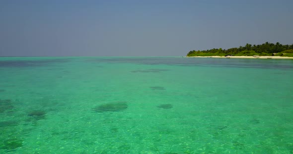 Beautiful birds eye travel shot of a white paradise beach and aqua turquoise water background in 4K alt
