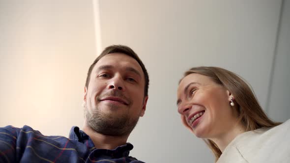 Young Happy Couple Opening Cardboard Box After Relocation Looking Inside alt