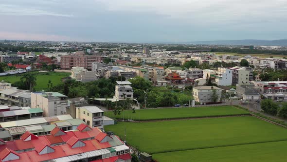 Aerial Drone Footage of Urban Agriculture with Grid Farm Land and Rice Paddy Field and residential h alt