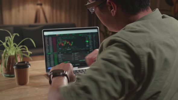 Man Trader Sitting In A Wheelchair And Stretching While Trading Data Index Chart Graph On Laptop alt