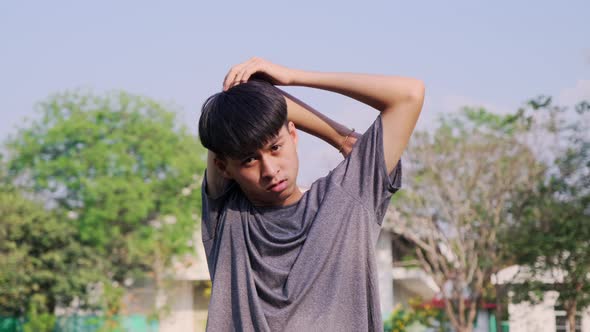 Healthy young man stretches to warm up before running in the park. alt