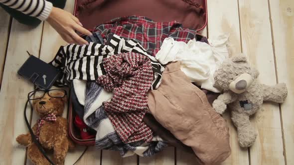 Faceless Traveler Woman Trying To Pack Clothes in Full Owerflowing Overfilled Luggage. Mess Nad alt