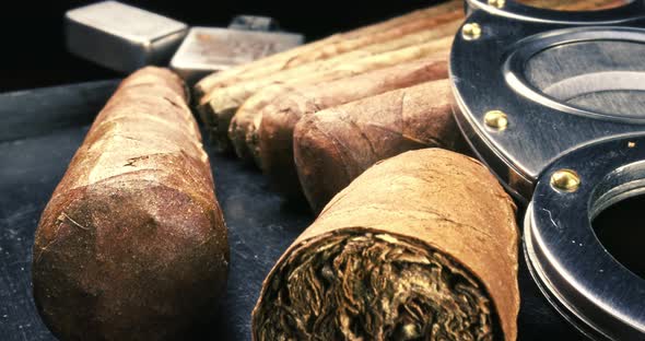 Closeup of cigars, lighter and cutter in humidor. alt