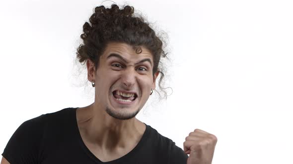 Closeup of Happy and Excited Handsome Guy with Curly Ponytail and Beard Making Fist Pump Gesture alt